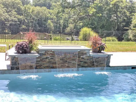 A custom-designed pool with a waterfall by Coastal Pools in Howard County, Maryland
