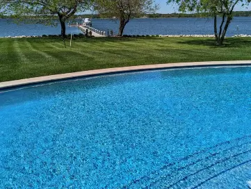 An arched pool with a large tanning ledge built by Coastal Pools in Maryland